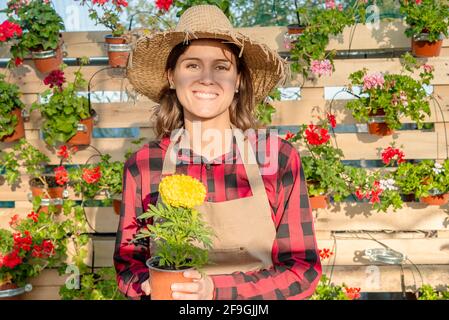 Junger lächelnder Gärtner in einem Blumenladen Stockfoto
