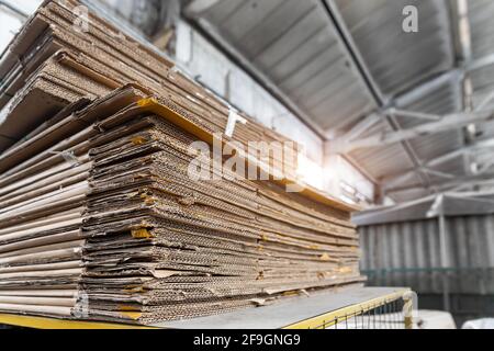 Stapeln Sie einen vorbereiteten Stapel aus gebrauchter komprimierter Wellpappe und Altpapierverpackung, der für das Recycling und die Wiederverwendung im Industriezentrum gesammelt wurde. Recycelbar Stockfoto