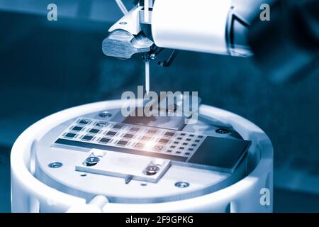 Nahaufnahme der Untersuchung der Testprobe des Mikrochip-Transistors unter dem Mikroskop im Labor. Ausrüstung zum Testen von Mikrochips. Automatisierung von Produ Stockfoto