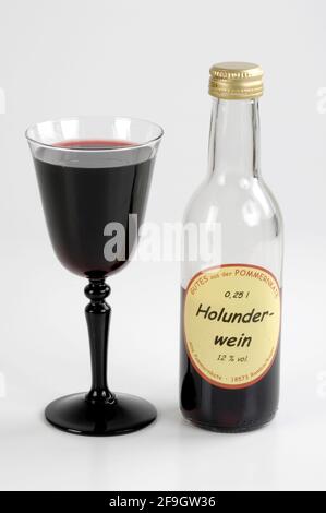 Holunderwein, Glas und Flasche, Schwarze Holunderbeere (Sambucus nigra), Wein im Glas und Flasche, Älterenwein, innen, Studio Stockfoto