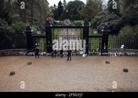 Sandringham, Großbritannien. April 2021. Die Menschen schauen Blumen vor den Norwich Gates an, da Sandringham am Tag nach dem Ableben von Prinz Philip, Herzog von Edinburgh, sehr düster ist. Vor den Toren Norwich, im Sandringham House, Norfolk, haben Menschen Blumen gezollt, was der Winterrückzug von Königin Elizabeth II. Ist Prinz Philip hat seit seiner Pensionierung im Jahr 2017 einen Großteil seiner Zeit in der Gegend von Sandringham verbracht. Kredit: Paul Marriott/Alamy Live Nachrichten Stockfoto