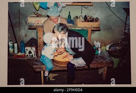 VIGO, SPANIEN - 02. Mai 1997: Schönes altes Foto Familie Moment Foto Großvater, Großmutter und Enkel. Großmutter küsst Kind in der m Stockfoto