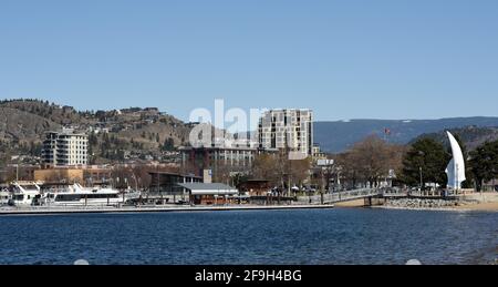 Ein Blick an Booten vorbei, die in einem Yachthafen am Okanagan Lake in der Innenstadt von Kelowna, British Columbia, Kanada, am Wasser festgemacht sind. Rechts ist der Spirit of Sail Stockfoto