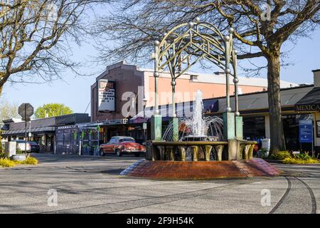 Die zeitlose Szene im Stadtzentrum von Edmonds an einem Frühlingstag findet den Edmonds Cedar Dreams Fountain, der vom Edmonds Theatre unterstützt wird, und einen klassischen Chevrolet Stockfoto