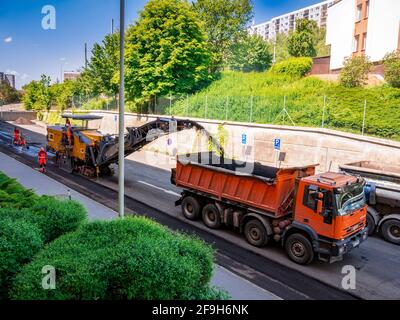 Usti nad Labem, Tschechische republik - 5.22.2018: Die Fräsmaschine entfernt alten Asphalt von der Straße und transportiert ihn auf einen LKW Stockfoto