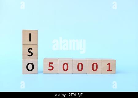 ISO 50001 oder Energy Management Systems Konzept auf Holzblöcken auf blauem Hintergrund. Stockfoto