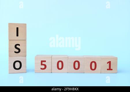 ISO 50001 oder Energy Management Systems Konzept auf Holzblöcken auf blauem Hintergrund. Stockfoto