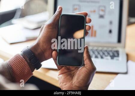 Nahaufnahme eines afroamerikanischen Geschäftsmannes mit Smartphone mit leerem schwarzen Bildschirm, mobiler App, Online-Banking-Konzept, Kopierraum Stockfoto