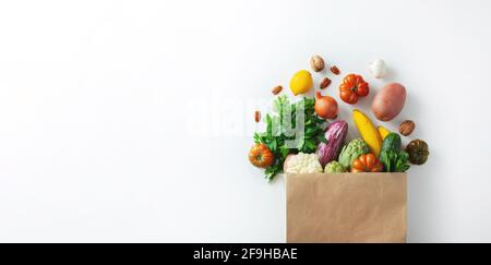 Hintergrund für gesunde Lebensmittel. Gesundes veganes vegetarisches Essen in Papiertüte Gemüse und Obst auf weiß, Kopierraum. Einkaufen Lebensmittel Supermarkt und sauber Stockfoto
