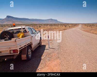 Ute auf der Gibb River Road in der Nähe der Pentecost Crossing mit den Cockburn Ranges in der Ferne, Kimberley, Westaustralien Stockfoto