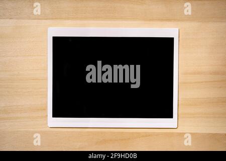 Fotorahmen im Format 4 x 6 Zoll auf Holzhintergrund Stockfoto