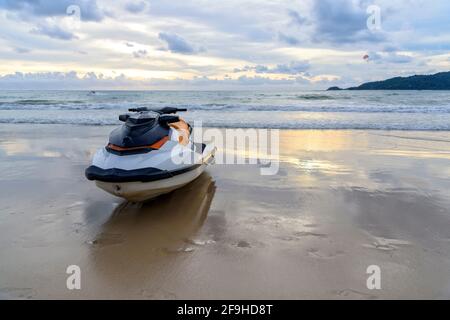 Parkplatz für Jet-Ski oder Wasserscooter am Strand zur Abendzeit mit Sonnenuntergang im Hintergrund. Stockfoto