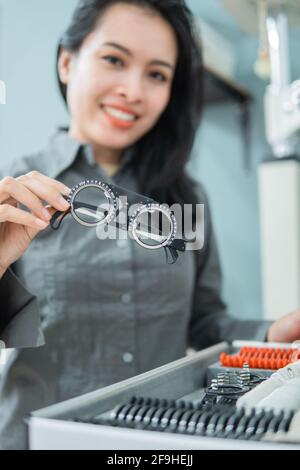 Eine Ärztin, die einen Augentest mit Messhilfe in der Hand hält Eine Augenklinik Stockfoto