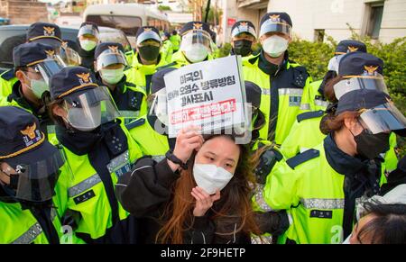 Studentenprotest gegen Japan, um Wasser aus Fukushima freizugeben, 17. Apr 2021: Polizisten blockieren Studenten, die versuchen, vor der japanischen Botschaft in Seoul, Südkorea, eine Pressekonferenz abzuhalten, während ihre Kollegen Protestierende vor der Botschaft eine Sitzdemonstration veranstalten. Sie protestierten gegen die Entscheidung der japanischen Regierung, radioaktives Wasser aus Fukushima abzuleiten. Auf einem Schild steht: "Wir verurteilen die US-Regierung, die ihre Unterstützung für die Entscheidung der japanischen Regierung zum Ausdruck gebracht hat, radioaktives Wasser aus der Atomenergie Fukushima Daiichi P abzuleiten Stockfoto