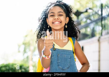 Kleines Mädchen lächelt und zeigt den Daumen hoch. Stockfoto