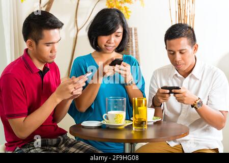 Asiaten Spaß zusammen mit Handy und trinken Kaffee oder cocktail Stockfoto