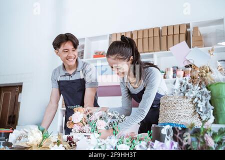 Fröhlicher junger Mann und Frau, die lächeln und während der Zusammenarbeit sprechen Stockfoto