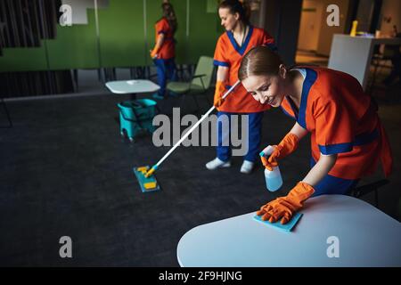 Hausmeister in Uniformen, die das Café aufräumen Stockfoto