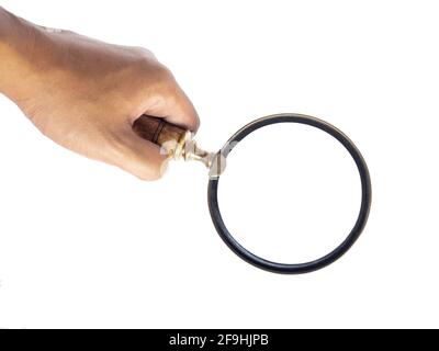 Hand hält alte Vintage Lupe isoliert auf weißem Hintergrund. Alte Vergrößerungsglas aus Holz und Gold. Stockfoto