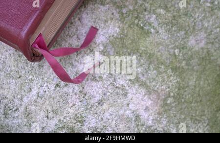 Nahaufnahme der Buchmarke in einem Buch, Draufsicht mit Steinhintergrund. Speicherplatz kopieren. Stockfoto