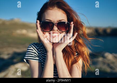 Fröhliche Frau trägt Sonnenbrillen Berge im Freien in der Nähe des Meeres Stockfoto