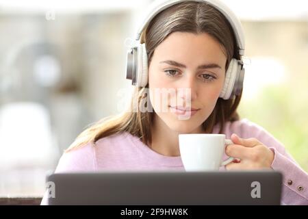 Vorderansicht Porträt einer Achtsamkeitsfrau, die Medien ansieht Laptop in einem Café Stockfoto