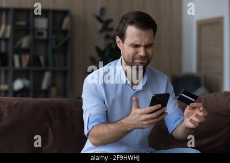 Unglücklicher männlicher Kunde, frustriert durch Fehler bei der Online-Zahlung Stockfoto