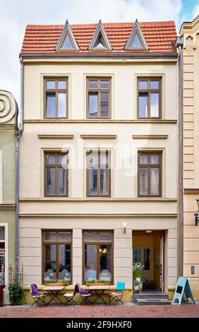 Schmal renoviertes Haus mit speziellen Dachfenstern und einem Restaurant in der Altstadt von Wismar. Stockfoto