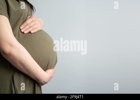 Gesunde Schwangerschaft. Seitenansicht schwanger Frau mit großem Bauch fortgeschrittenen Schwangerschaft in den Händen. Banner-Textbereich für Text Stockfoto