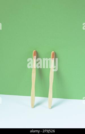 Zwei Bambuszahnbürsten auf grünem und weißem Hintergrund. Persönliche Hygiene, Zero Waste Konzept. Stockfoto