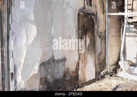 Beschädigte Wand mit Spuren von Brennen und schwarzem Ruß im Gebäude nach dem Brand. Brandstiftung Untersuchung. Horizontales Bild. Seitenansicht. Stockfoto