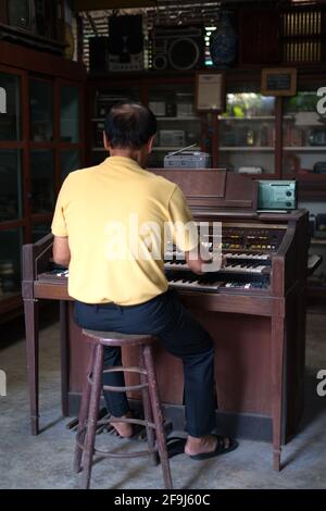 Der alte asiatische Mann spielte Klavier. Retro-Style. Bangkok, Thailand, 5. Januar 2020. Stockfoto