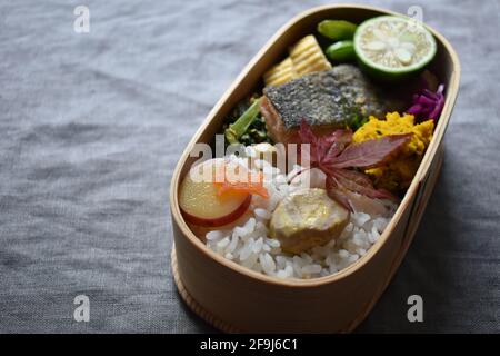 Wappa Bento, japanische Lunchbox mit runder Holzplatte, Lachs Meuniere Stockfoto