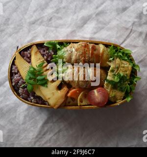 Wappa Bento, japanische Lunchbox mit runder Holzplatte, mit Fleisch umwickelte Snap Bean Stockfoto