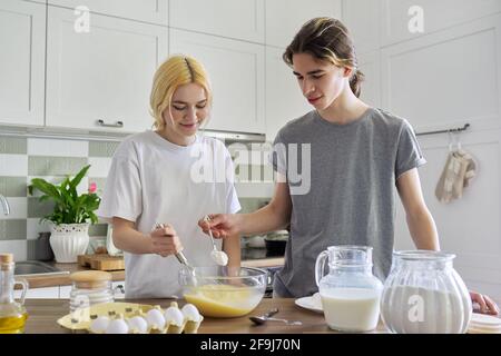 Teenager Kerl und Mädchen Kochen Pfannkuchen in der Küche zusammen Stockfoto