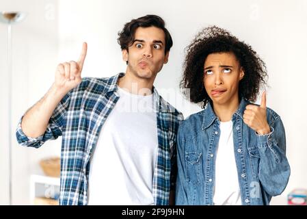 Junge lustige fröhliche Paar in der Liebe, afroamerikanische Mädchen und gemischt Rennen Kerl, um zu täuschen, machen Gesichter, sehen lustig und fröhlich, Spaß zusammen Stockfoto