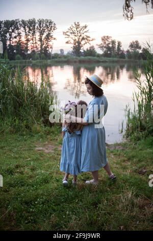 Die Mutter umarmt ihre Tochter im Freien in der Natur Stockfoto