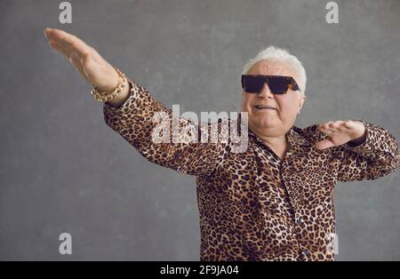 Studio Porträt von lustigen Tanz reichen älteren Mann in Leopard shirt und coole Brille Stockfoto