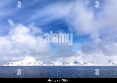 Unberührte schneebedeckte Berge und blauer Sommerhimmel. Svalbard, ein norwegischer Archipel zwischen dem norwegischen Festland und dem Nordpol Stockfoto