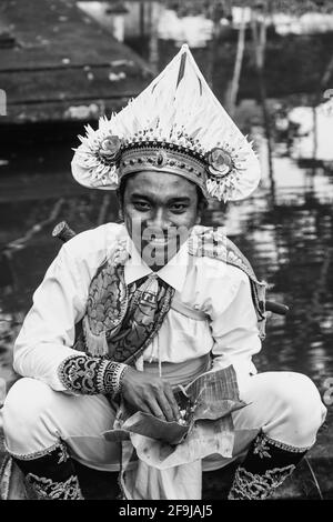 Ein junger Mann im Kostüm, der Mittagessen auf EINEM Hindu-Festival, dem Wassertempel von Tyrta Empul, Bali, Indonesien, isst. Stockfoto