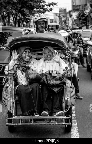 Zwei Lächelnde Indonesische Frauen, Die Mit Dem Motorrad-Taxi In Yogyakarta, Indonesien Reisen. Stockfoto