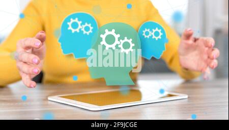 Digitales Tablet mit Brainstorming-Konzept zwischen den Händen einer Frau im Hintergrund Stockfoto