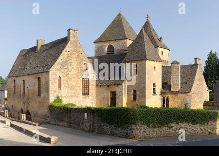 Die Kirche Notre Dame de l'Assomption und das angrenzende Schloss im Zentrum von Saint-Geniès, Dordogne, Frankreich Stockfoto