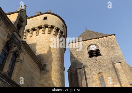 Der Turm der Kirche Notre Dame de l'Assomption und ein Teil des angrenzenden Schlosses im Zentrum von Saint-Geniès, Dordogne, Frankreich Stockfoto