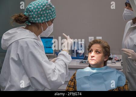 Frau Zahnarzt in der Zahnarztpraxis im Gespräch mit weiblichen Patienten und Vorbereitung für die Behandlung. Stockfoto