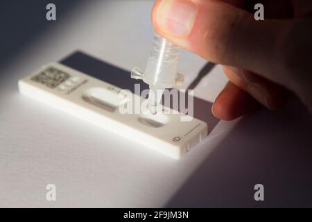 Eine Hand, die eine Probe und Testlösung auf den Lateral Flow Test tropft LFT LFD (chinesisch hergestellt) Lateral Flow Device des Unternehmens Innova: Testing for COVID 19 Coronavirus Antigen Testing. (123) Stockfoto