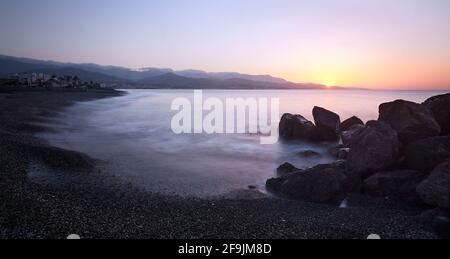Wunderschöne Aufnahme eines Sonnenuntergangs am Strand Torre del Mar in Malaga, Spanien Stockfoto