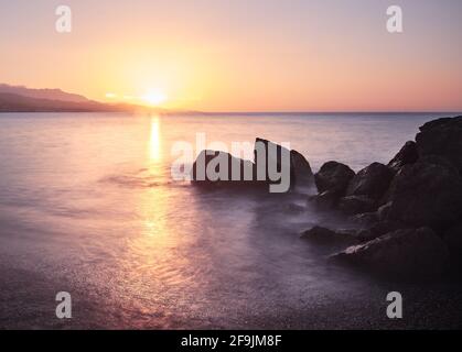 Wunderschöne Aufnahme eines Sonnenuntergangs am Strand Torre del Mar in Malaga, Spanien Stockfoto