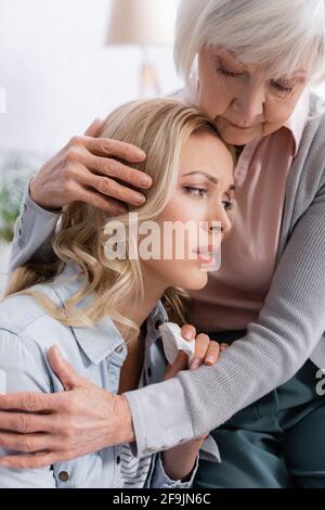 Ältere Mutter beruhigt und umarmt verärgert Tochter zu Hause Stockfoto
