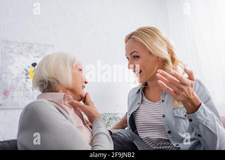 Lächelnde Mutter und Tochter unterhalten sich zu Hause Stockfoto
